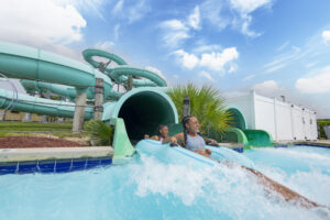 Two girls laughing as they splash down a water slide at Sun Splash Family Waterpark in Cape Coral, Florida